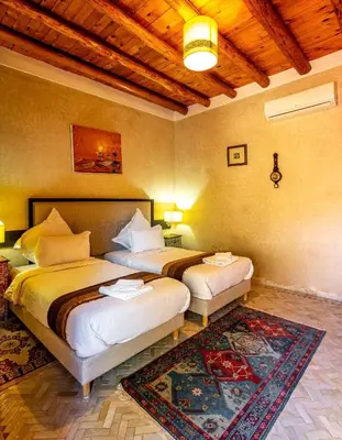 a bedroom with two beds and a rug at Riad Citronnelle in Marrakech
