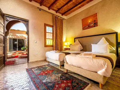 a bedroom with two beds in a room with a doorway at Riad Citronnelle in Marrakech