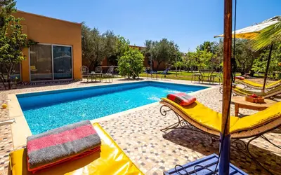 a swimming pool with two chairs and a table at Riad Citronnelle in Marrakech