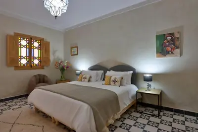 a bedroom with a large white bed and a window at Riad Banatti in Marrakech