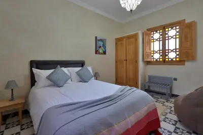 a bedroom with a large white bed and a window at Riad Banatti in Marrakech