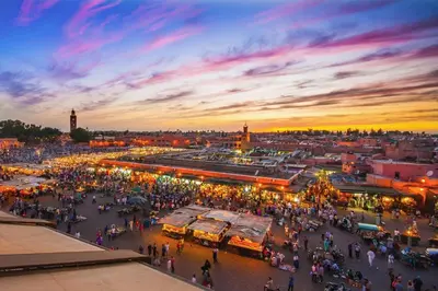 a crowd of people walking around a market at sunset at Royal Deluxe Silver - Marrakech, Luxe Pool View in Marrakech