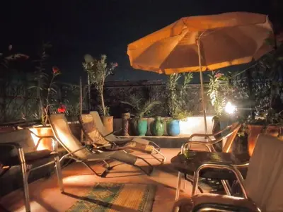 a group of chairs and an umbrella on a patio at Riad Dar Zaida in Marrakech