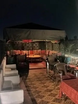 a room with a tent with chairs and tables at Riad Dar Zaida in Marrakech