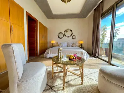 a bedroom with a bed and a table and a chair at Riad villa saphir & SPA in Marrakech
