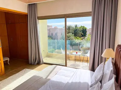 a bedroom with a bed and a large window at Riad villa saphir & SPA in Marrakech