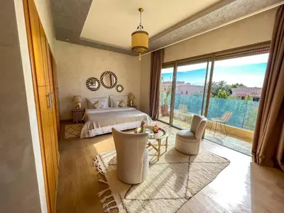 a bedroom with a bed and a large window at Riad villa saphir & SPA in Marrakech