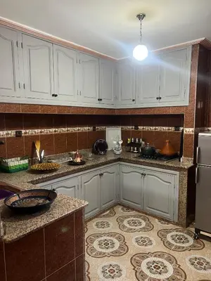 a kitchen with white cabinets and a refrigerator at Appartment Khadija in Marrakech