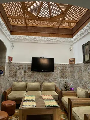 a living room with a couch and a tv on a wall at Appartment Khadija in Marrakech