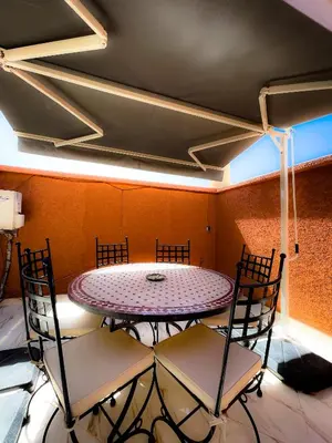 a dining room with a table and chairs at Riad Nour Travel in Marrakech