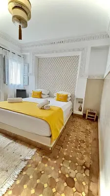 a bedroom with a large bed with a yellow blanket at Riad Magnolia&SPA in Marrakech