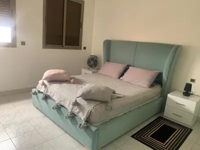 a bed with pink pillows on it in a room at APPARTEMENT PERLE RARE AU CENTRE DE MARRAKECH in Marrakech