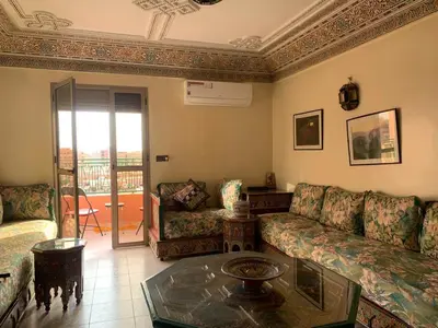 a living room with a couch and a table at APPARTEMENT PERLE RARE AU CENTRE DE MARRAKECH in Marrakech