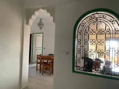 a mirror hanging on a wall next to a dining room at APPARTEMENT PERLE RARE AU CENTRE DE MARRAKECH in Marrakech