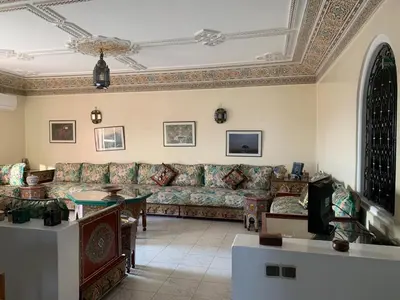 a living room with a couch and a table at APPARTEMENT PERLE RARE AU CENTRE DE MARRAKECH in Marrakech