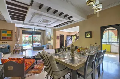 a dining room and living room with a table and chairs at VILLA Garden in Marrakech