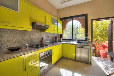 a yellow kitchen with yellow cabinets and a window at VILLA Garden in Marrakech