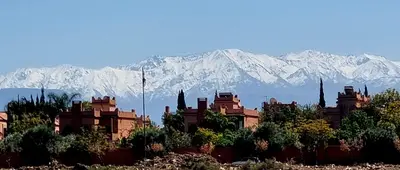 a building with mountains in the background in front at VILLA Garden in Marrakech