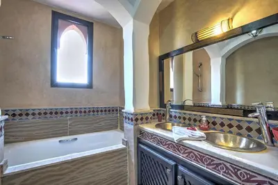 a bathroom with a sink and a tub and a mirror at VILLA Garden in Marrakech