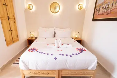 a bedroom with a large white bed with flowers on it at Riad El Habib in Marrakech