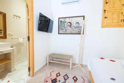a bathroom with a bed and a sink and a mirror at Riad El Habib in Marrakech