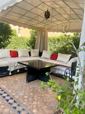 a couch under an umbrella on a patio at Villa Aalama in Marrakech