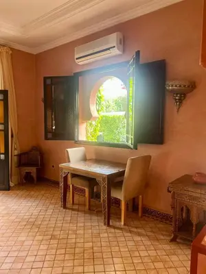 a dining room with a table and a window at Villa Aalama in Marrakech