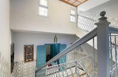 a staircase with a blue cabinet in a house at Très Beau Riad à Marrakech avec piscines in Marrakech