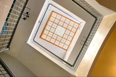 a window in a stairwell with a tile wall at Très Beau Riad à Marrakech avec piscines in Marrakech