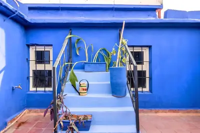 a blue house with blue stairs and plants at Très Beau Riad à Marrakech avec piscines in Marrakech