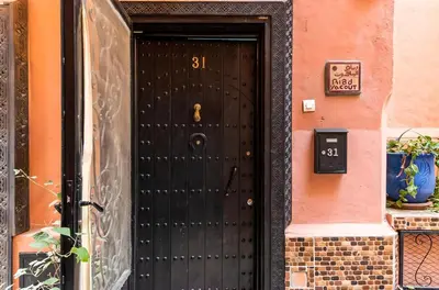 a black door to a building with a number on it at Très Beau Riad à Marrakech avec piscines in Marrakech