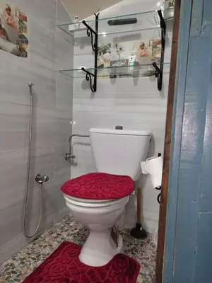 a bathroom with a toilet with a red seat at Très Beau Riad à Marrakech avec piscines in Marrakech