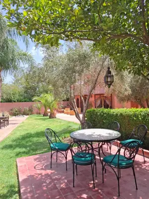 a patio with a table and chairs in a yard at RIAD - Jnan Bnati - Pool in Marrakech