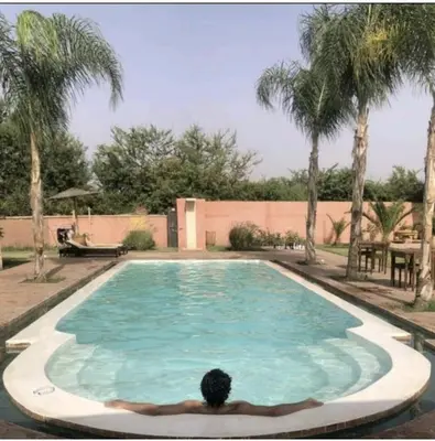 a person laying in front of a swimming pool at RIAD - Jnan Bnati - Pool in Marrakech