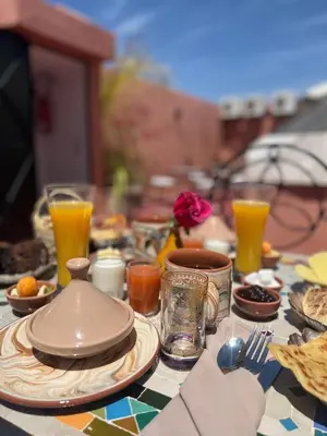a table with plates of food and orange juice at Riad Malfa in Marrakech