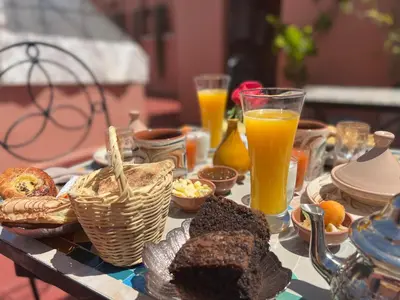 a table with bread and orange juice and drinks at Riad Malfa in Marrakech