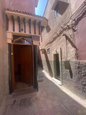 an alley with a wooden door in a building at Riad Sabah in Marrakech