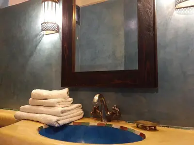 a bathroom with a sink with towels and a mirror at Riad Sabah in Marrakech
