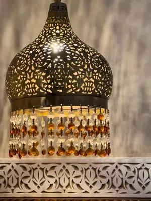 a chandelier with a light on top of a table at Perlekech Riad & Spa in Marrakech