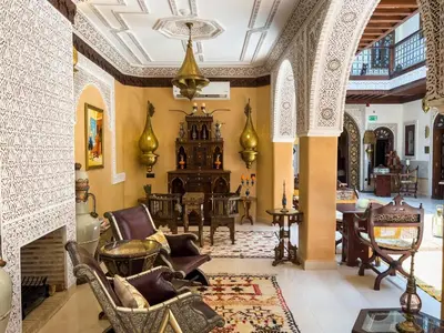 a living room with chairs and a fireplace at Perlekech Riad & Spa in Marrakech