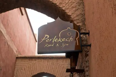 a sign for a restaurant on the side of a building at Perlekech Riad & Spa in Marrakech