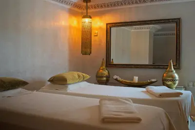 a bedroom with two beds with a mirror and a mirror at Perlekech Riad & Spa in Marrakech