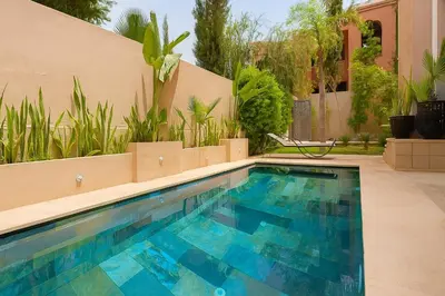 a swimming pool in front of a house at SABOR VILLA TARGA GARDEN -Only Family in Marrakech