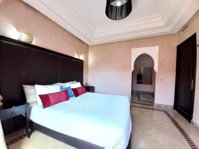 a bedroom with a large white bed with red pillows at SABOR VILLA TARGA GARDEN -Only Family in Marrakech