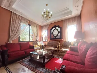 a living room with red furniture and a chandelier at SABOR VILLA TARGA GARDEN -Only Family in Marrakech
