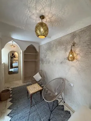 a living room with a chair and a fan at Riad Yu Yu in Marrakech