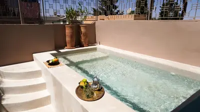 a swimming pool with a bowl of fruit on a table at Riad Home Zemrane in Marrakech