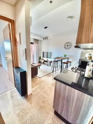 a kitchen and living room with a table and chairs at Magnifique appartement Résidence DOMAINE DE NORIA in Marrakech