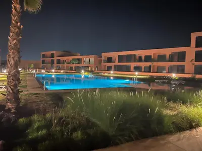 a building with a swimming pool at night at Magnifique appartement Résidence DOMAINE DE NORIA in Marrakech