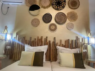 a room with a couch with hats on the wall at Riad Palmier fleuri in Marrakech